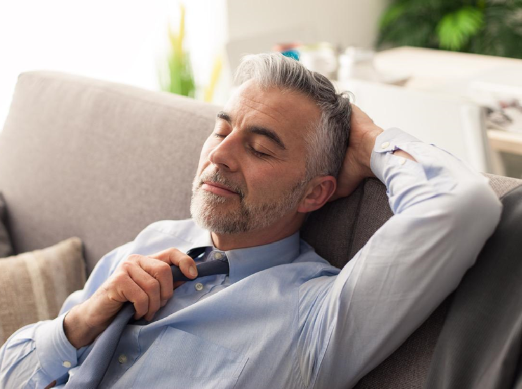 Older man on couch practicing CBT and mindfulness